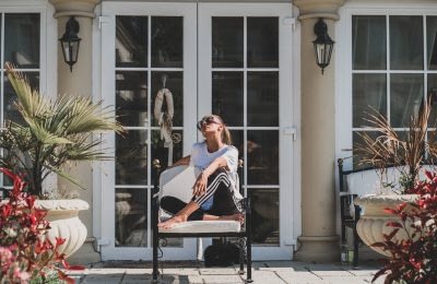 Frau auf einem Stuhl auf einer Terrasse